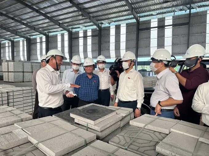 Deputy Chairman of the National Assembly Le Minh Hoan (second from left) and the supervision delegation listen as BIWASE leaders explain the process of producing recycled bricks from waste on July 24 01.jpg