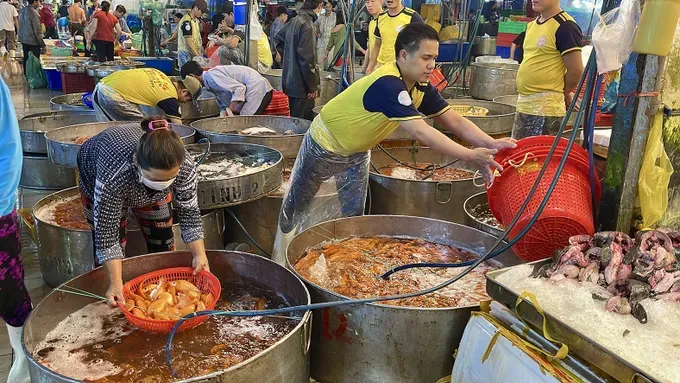 Traders at Binh Dien Wholesale Market are busily preparing seafood for overnight delivery to customers (Photo: SGGP) 15.jpg