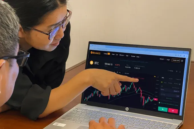 A user is browsing information on the digital currency market via the online exchange Binance (Photo: SGGP) 25.jpg