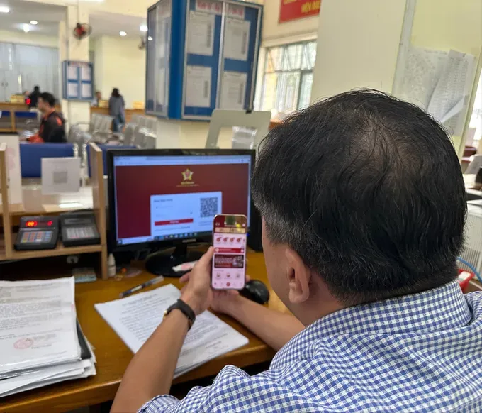 An official at Thong Tay Hoi Ward in HCMC is processing a construction permit application submitted by a resident via the online system 45.jpg