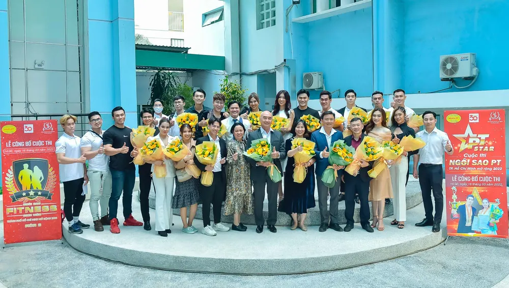 Các thầy cô chụp ảnh lưu niệm trước trường Trường Đại học HUFLIT.