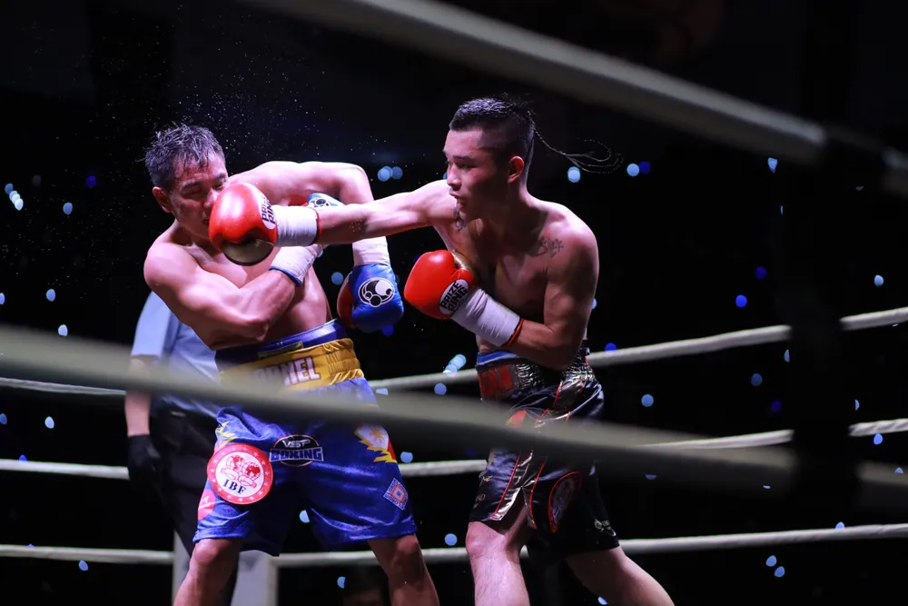Đinh Hồng Quân (bao tay đỏ) bị tước đai trước thềm sự kiện Boxing "bom tấn" Fortunes of War - Nhưng vẫn chiến thắng đầy cảm xúc trước Arnel Baconaje tối 10-12. Ảnh: Nhật Anh
