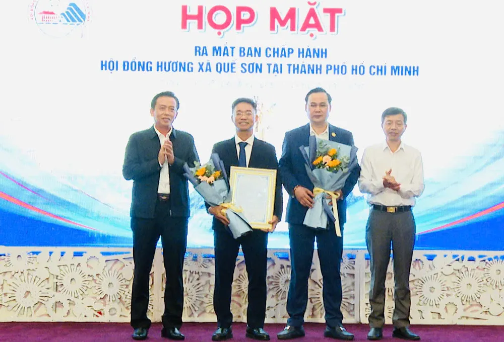 Ông Ngô Công Quang và ông Hà Văn Tự (giữa) nhận hoa chúc mừng từ lãnh đạo địa phương,