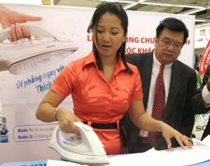 A potential customer tests a Philips steam iron with a shirt while Philips Vietnam CEO Pratt Hsu watches during the introduction of Philips steam irons in HCM City May 28 (Photo: Tuong Thuy) A potential customer tests a Philips steam iron with a shirt while Philips Vietnam CEO Pratt Hsu watches during the introduction of Philips steam irons in HCM City May 28 (Photo: Tuong Thuy)