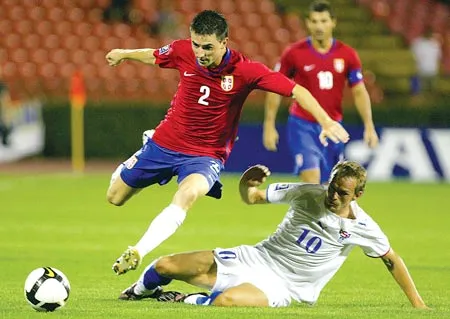 Antonio Rukavina (trái, Serbia) đi bóng qua Christian Jacobsen (Đảo Faroe).