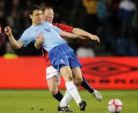 Hậu vệ Na Uy Fredrik Winsnes bám chặt lấy tiền vệ Hà Lan Marc Van Bommel