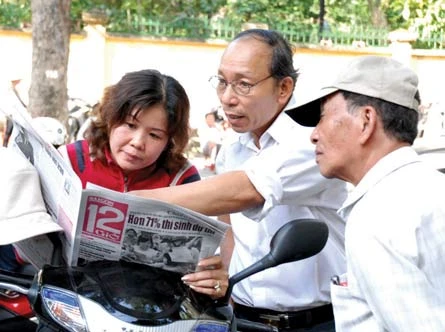 Phụ huynh xem gợi ý giải đề thi trên Báo SGGP 12 Giờ trong lúc chờ thí sinh thi. (Ảnh chụp trước Trường THPT Trưng Vương). Ảnh: CAO THĂNG. Phụ huynh xem gợi ý giải đề thi trên Báo SGGP 12 Giờ trong lúc chờ thí sinh thi. (Ảnh chụp trước Trường THPT Trưng Vương). Ảnh: CAO THĂNG.
