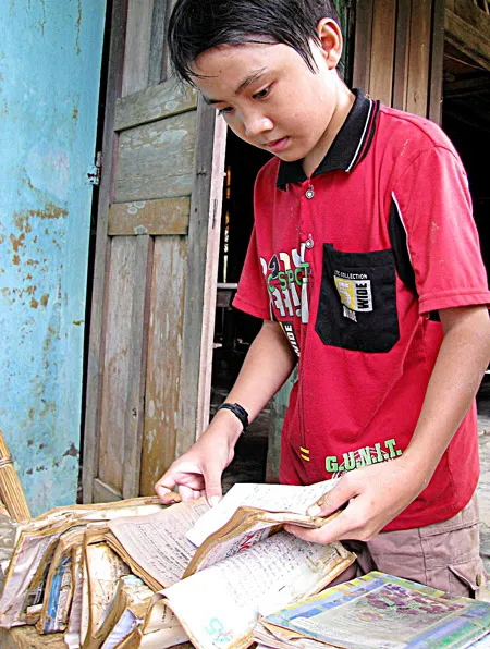 Em Nguyễn Hữu Đức (thôn 8 Đại Hưng, Quảng Nam) sắp xếp sách vở bị ngâm nước. Em Nguyễn Hữu Đức (thôn 8 Đại Hưng, Quảng Nam) sắp xếp sách vở bị ngâm nước.