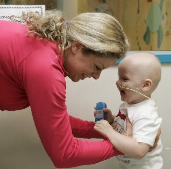 Kim Clijsters interacts with a young boy while on a visit to the Royal Brisbane Children's Hospital in Brisbane on December 31, 2009. AFP PHOTO