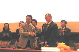 ACB chief executive Ly Xuan Hai (L) shakes hand with Chartis Vietnam acting CEO Ronald Hudon after signing their cooperation agreement Jan. 6, 2010