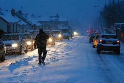 Cars drive on a snow covered street following heavy snow in Cherbourg, France. Cars drive on a snow covered street following heavy snow in Cherbourg, France.