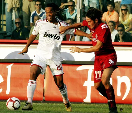 Tiền vệ Milan Ronaldinho (trái) đi bóng qua hậu vệ Livorno