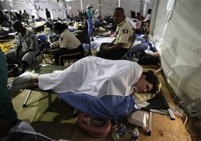 Two Haitian police officers sit next to Charisa Coulter, 24, of Boise, Idaho, one of the 10 Americans who were arrested while trying to bus children out of Haiti without proper documents or government permission, as she rests on a cot at the University of Miami's field hospital, near Port-au-Prince's international airport. Two Haitian police officers sit next to Charisa Coulter, 24, of Boise, Idaho, one of the 10 Americans who were arrested while trying to bus children out of Haiti without proper documents or government permission, as she rests on a cot at the University of Miami's field hospital, near Port-au-Prince's international airport.