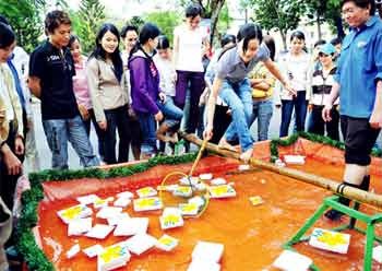 A worker takes part in a game held by a HCM City-based company for workers who will work through Tet holidays. Many workers will be paid a double or triple pay for working during Tet. (Photo: SGGP) A worker takes part in a game held by a HCM City-based company for workers who will work through Tet holidays. Many workers will be paid a double or triple pay for working during Tet. (Photo: SGGP)