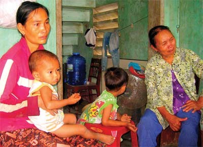 Truong Thi Kim Lien (1st L) with her mother-in-law and two children in her house, her husband was swept away by floods on November 3 (Photo: SGGP) Truong Thi Kim Lien (1st L) with her mother-in-law and two children in her house, her husband was swept away by floods on November 3 (Photo: SGGP)