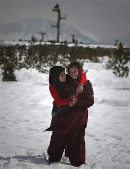 Afghan girls look on as they stand in snow on a hilltop in Kabul, Afghanistan, Monday, Feb. 8, 2010. Afghan girls look on as they stand in snow on a hilltop in Kabul, Afghanistan, Monday, Feb. 8, 2010.