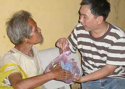 A poor old man receives presents from an SGGP reporter on February 10. (December 27 lunar calendar) (Photo: SGGP) A poor old man receives presents from an SGGP reporter on February 10. (December 27 lunar calendar) (Photo: SGGP)