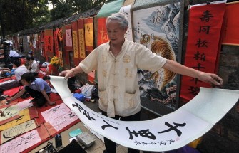 This file photo taken on February 8, 2010 shows a calligrapher folding a hanging paper he wrote out for a customer outside the Temple of Literature in downtown Hanoi ahead of the Lunar New Year holidays, or Tet. AFP photo This file photo taken on February 8, 2010 shows a calligrapher folding a hanging paper he wrote out for a customer outside the Temple of Literature in downtown Hanoi ahead of the Lunar New Year holidays, or Tet. AFP photo