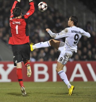 Real Madrid forward Cristiano Ronaldo (R) kicks the ball despite Lyon goalkeeper Hugo Lloris (L) during the Champion's League football match Lyon Vs Real Madrid, on February 16, 2010 in Lyon. AFP PHOTO Real Madrid forward Cristiano Ronaldo (R) kicks the ball despite Lyon goalkeeper Hugo Lloris (L) during the Champion's League football match Lyon Vs Real Madrid, on February 16, 2010 in Lyon. AFP PHOTO