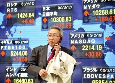 A Japanese businessman walks past a share prices board in Tokyo A Japanese businessman walks past a share prices board in Tokyo