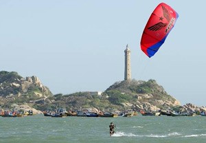 Kite surfing on Ke Ga Bay with Ke Ga Lighthouse in the background Kite surfing on Ke Ga Bay with Ke Ga Lighthouse in the background