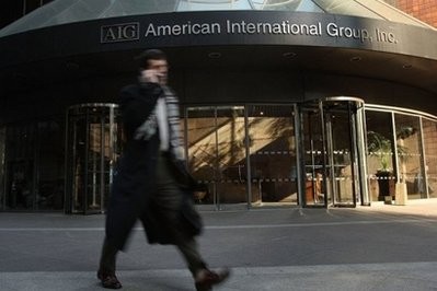 A man walks by the American International Group (AIG) building in New York City. A man walks by the American International Group (AIG) building in New York City.