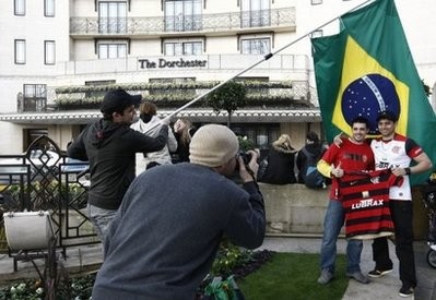 Brazilian football fans have their photo taken in front of a Brazil flag while waiting outside the Dorchester Hotel in central London. Brazilian football fans have their photo taken in front of a Brazil flag while waiting outside the Dorchester Hotel in central London.