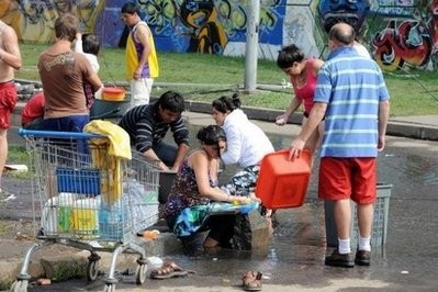 Residents wash clothes in a street in Concepcion, Chile. Residents wash clothes in a street in Concepcion, Chile.
