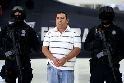 Guarded by police officers, Jose Antonio Medina, aka Don Pepe, center, is presented to the press in Mexico City.