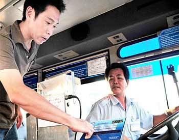 A passenger uses an automatic ticket-selling machine being trialed on a city bus (Photo: SGGP) A passenger uses an automatic ticket-selling machine being trialed on a city bus (Photo: SGGP)