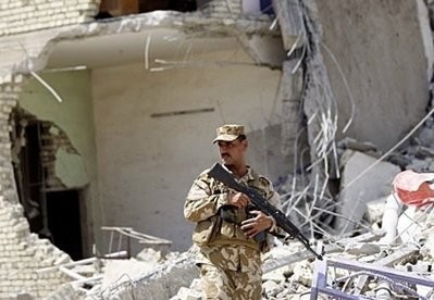 An Iraqi soldier stands amid the rubble of a destroyed residential building in the western Baghdad district of Shukuk An Iraqi soldier stands amid the rubble of a destroyed residential building in the western Baghdad district of Shukuk