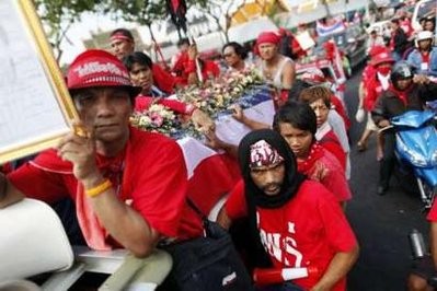 Anti-government red shirt demonstrators follow vehicles carrying the coffins of those killed during clashes with security forces two days earlier, as they protest through the streets of Bangkok April 12, 2010. Anti-government red shirt demonstrators follow vehicles carrying the coffins of those killed during clashes with security forces two days earlier, as they protest through the streets of Bangkok April 12, 2010.
