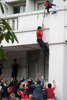Red Shirt anti-government leader Arisman Pongruanrong is helped by others as he flees arrest on April 16, at the SC Park Hotel in Bangkok Red Shirt anti-government leader Arisman Pongruanrong is helped by others as he flees arrest on April 16, at the SC Park Hotel in Bangkok