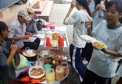 Students eat food prepared by roadside vendors in front of Le Quy Don Junior High School in HCMC. Despite a recent outbreak of cholera, most students and residents continue to eat from the generally unhygienic eateries ( Photo: SGGP) Students eat food prepared by roadside vendors in front of Le Quy Don Junior High School in HCMC. Despite a recent outbreak of cholera, most students and residents continue to eat from the generally unhygienic eateries ( Photo: SGGP)