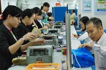 Deals at a branch of Eximbank. Many banks lower lending rates to 15 percent on average, while the selling price of USD declines to around VND19,000 (Photo: SGGP) Deals at a branch of Eximbank. Many banks lower lending rates to 15 percent on average, while the selling price of USD declines to around VND19,000 (Photo: SGGP)