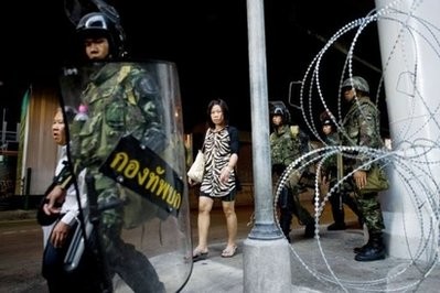 Thai office workers walk past armed soldiers in the Silom business district of Bangkok. AFP photo Thai office workers walk past armed soldiers in the Silom business district of Bangkok. AFP photo