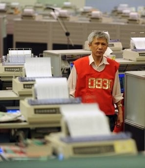 A trader walks through the Hong Kong Stock Exchange. A trader walks through the Hong Kong Stock Exchange.
