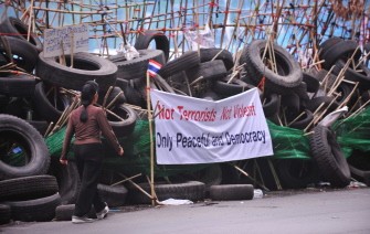 A woman walks past an anti-government Red Shirt protesters' barricade made up of used tires in the central quarter of Silom in downtown Bangkok on April 24, 2010. AFP photo A woman walks past an anti-government Red Shirt protesters' barricade made up of used tires in the central quarter of Silom in downtown Bangkok on April 24, 2010. AFP photo