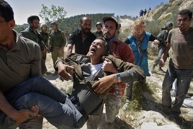 Palestinians carry an injured man during a demonstration against the construction of Israel's separation barrier in the West Bank village of Walajeh Palestinians carry an injured man during a demonstration against the construction of Israel's separation barrier in the West Bank village of Walajeh