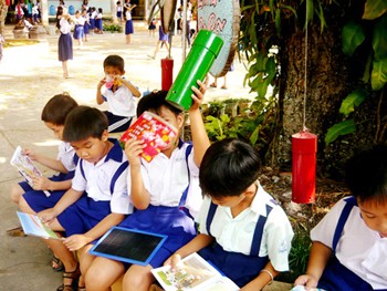 Students reading books from at a “hanging library” at Thieng Duc Primary School in Vinh Long Province. (Photo: SGGP) Students reading books from at a “hanging library” at Thieng Duc Primary School in Vinh Long Province. (Photo: SGGP)
