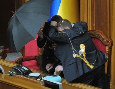Security personnel protect the Speaker of Ukraine's parliament Volodymyr Liytvyn with umbrellas during a fight at a parliament sitting in Kiev. Security personnel protect the Speaker of Ukraine's parliament Volodymyr Liytvyn with umbrellas during a fight at a parliament sitting in Kiev.