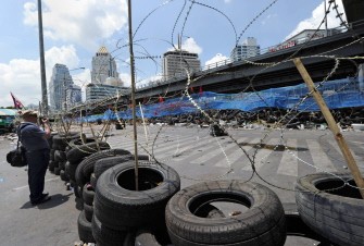 A foreign reporter takes pictures of a barricade made of used truck tyres and sharpened bamboo sticks inside the anti-government Red Shirt protesters' fortified camp in the financial central district of downtown Bangkok on April 29, 2010. AFP photo A foreign reporter takes pictures of a barricade made of used truck tyres and sharpened bamboo sticks inside the anti-government Red Shirt protesters' fortified camp in the financial central district of downtown Bangkok on April 29, 2010. AFP photo