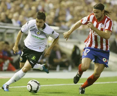 Villa đi bóng qua hậu vệ Ujfalusi của Atletico trận đấu giữa 2 đội tại Liga. Villa đi bóng qua hậu vệ Ujfalusi của Atletico trận đấu giữa 2 đội tại Liga.