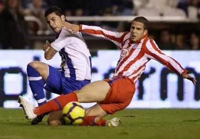 Hậu vệ Dominguez của Atletico cố ngăn cản quả tạt bóng của Riki trong trận lượt đi. Hậu vệ Dominguez của Atletico cố ngăn cản quả tạt bóng của Riki trong trận lượt đi.
