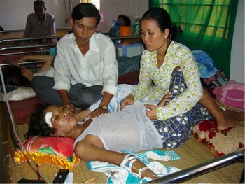 Hoang Anh tended to by his mother and stepfather at Dam Doi General Hospital in Ca Mau Province (Photo: Tuoi Tre) Hoang Anh tended to by his mother and stepfather at Dam Doi General Hospital in Ca Mau Province (Photo: Tuoi Tre)