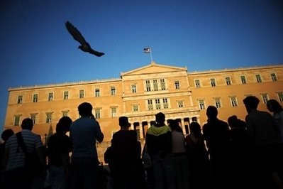 People attend a protest against the government's austerity measures as they stand outside the Greek Parliament in the center of Athens. People attend a protest against the government's austerity measures as they stand outside the Greek Parliament in the center of Athens.