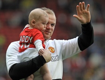 Wayne Rooney holding his son, Kai on the pitch after the English Premier League football match between Manchester United and Stoke City at Old Trafford on May 9, 2010. AFP PHOTO Wayne Rooney holding his son, Kai on the pitch after the English Premier League football match between Manchester United and Stoke City at Old Trafford on May 9, 2010. AFP PHOTO