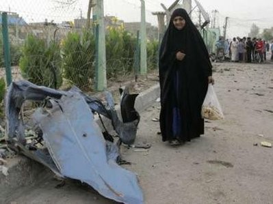A woman walks past a piece of a destroyed car at the site of Wednesday's bomb attack in Baghdad May 13, 2010. Seven people were killed and 22 wounded after a car bomb planted outside a cafe exploded in Baghdad's Sadr City A woman walks past a piece of a destroyed car at the site of Wednesday's bomb attack in Baghdad May 13, 2010. Seven people were killed and 22 wounded after a car bomb planted outside a cafe exploded in Baghdad's Sadr City