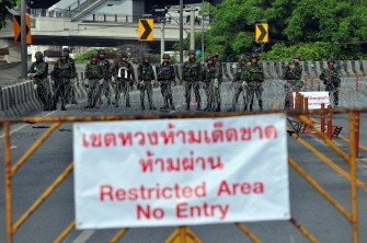 Armed soldiers stand behind barbed wire after they restricted access to an area on the fringes of the anti-government protest site in downtown Bangkok on May 18, 2010. AFP photo Armed soldiers stand behind barbed wire after they restricted access to an area on the fringes of the anti-government protest site in downtown Bangkok on May 18, 2010. AFP photo