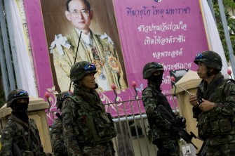 Thai soldiers stand guard in front of a portrait of Thai King Bhumibol Adulyadej around near the Red Shirt anti-government protest site in downtown Bangkok on May 17, 2010. AFP photo Thai soldiers stand guard in front of a portrait of Thai King Bhumibol Adulyadej around near the Red Shirt anti-government protest site in downtown Bangkok on May 17, 2010. AFP photo
